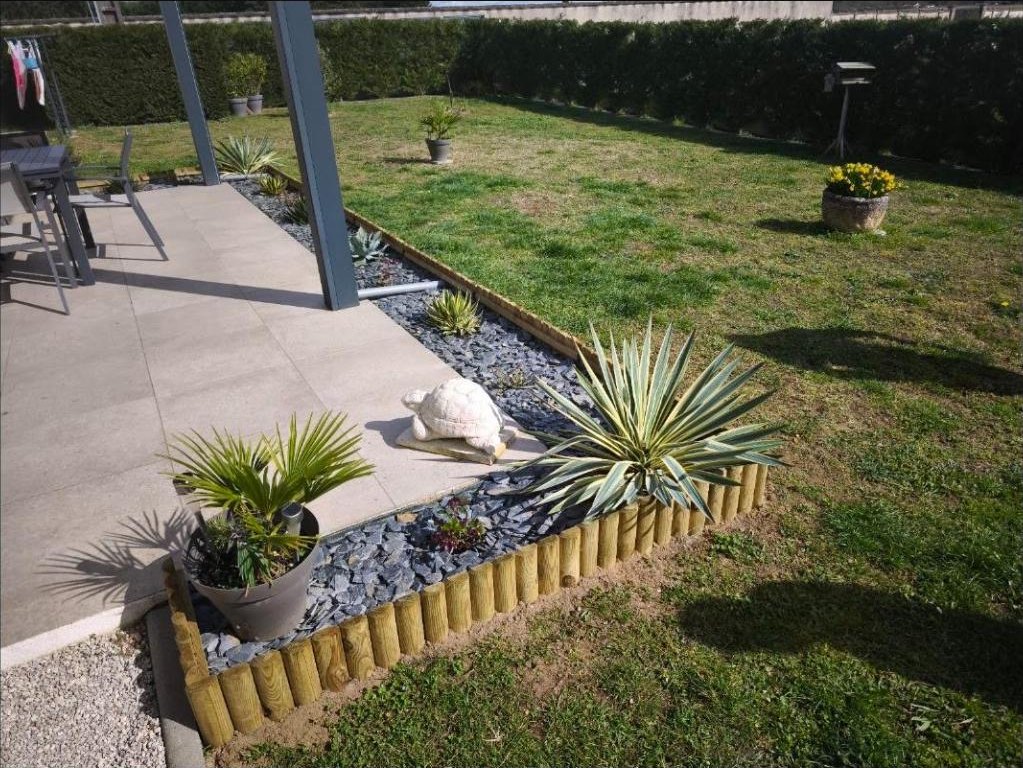 Massif minéral avec bordure bois et plantes