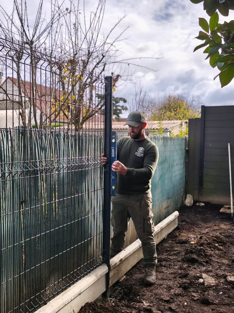 Steven posant une clôture rigide au niveau