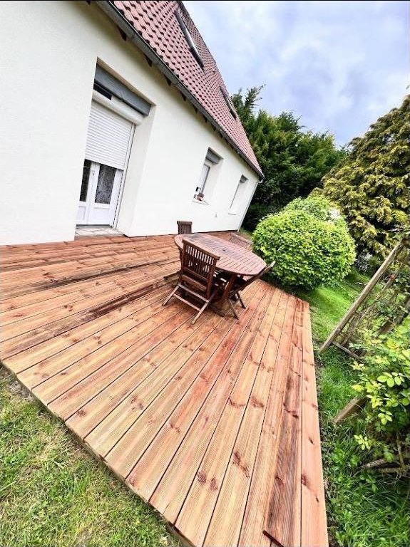 Terrasse en bois posée devant une maison